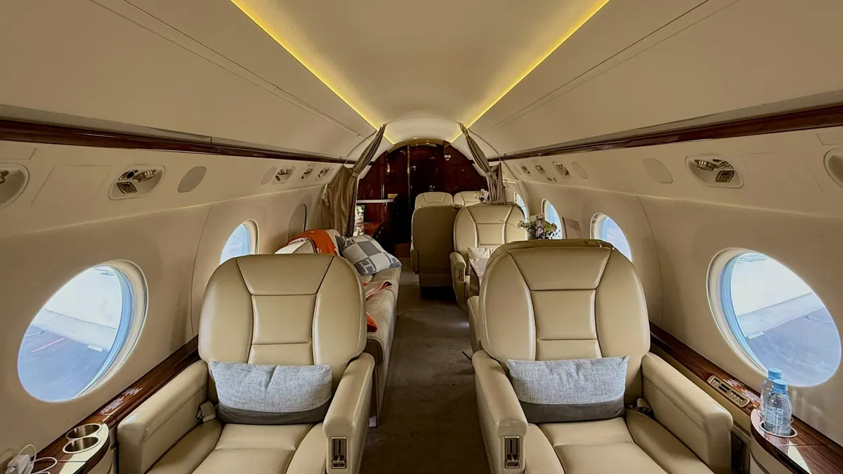 Warmly lit private jet cabin with leather seats